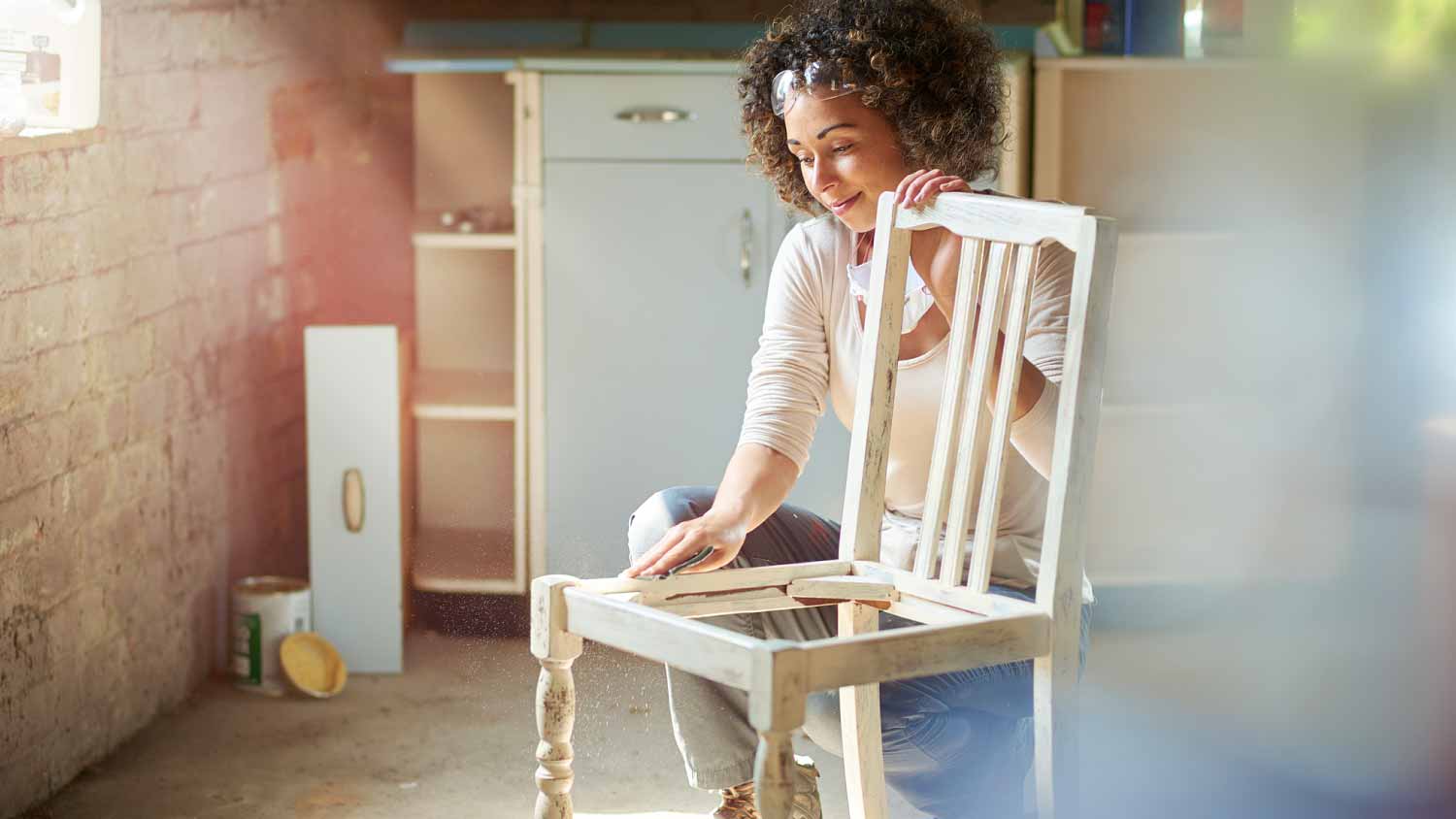 Woman restoring an old wooden chair
