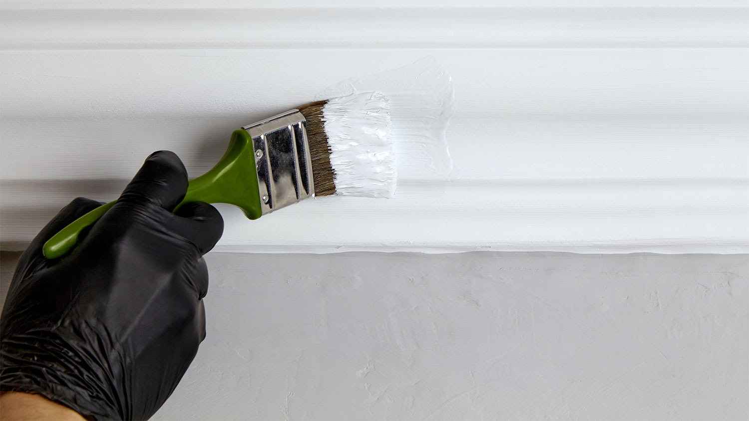 man with gloves painting ceiling trim