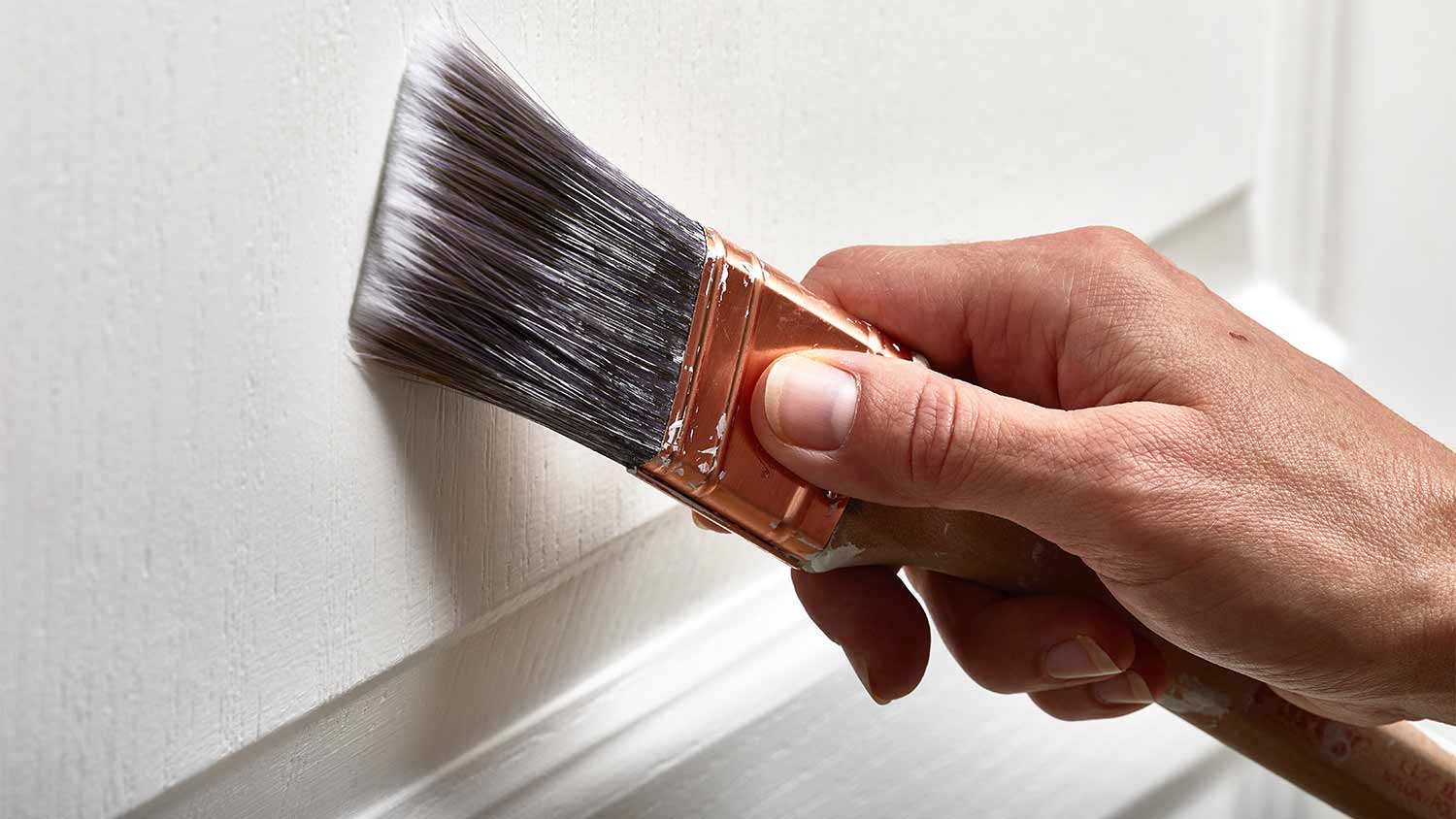 man painting trim on door