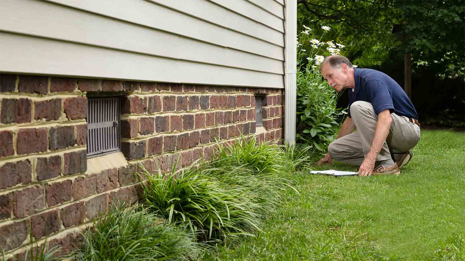 inspector examining home’s brick foundation