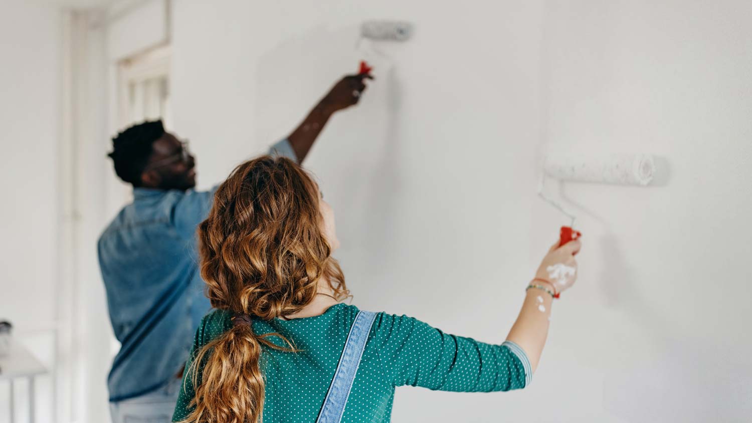 A young couple painting a room