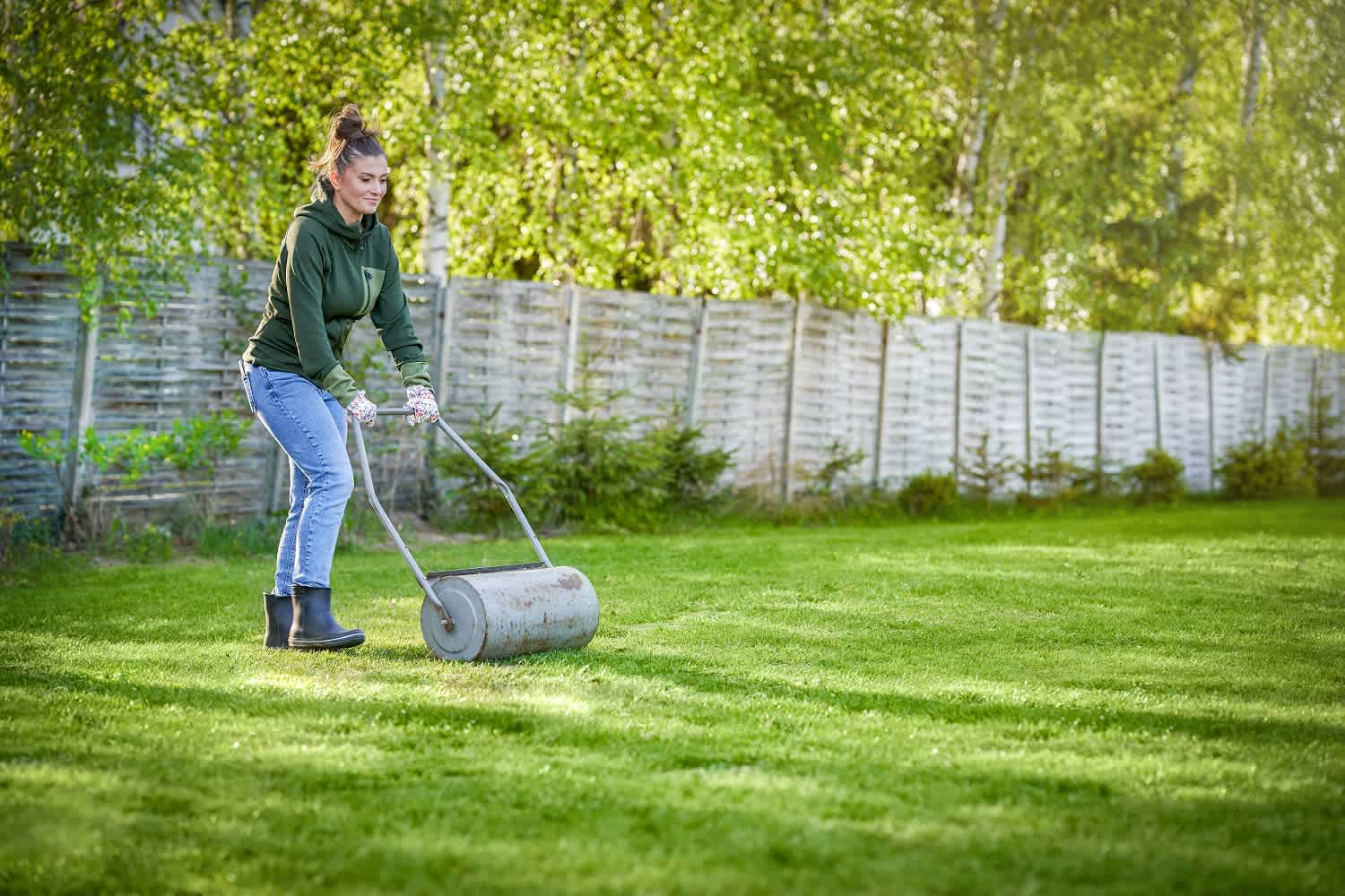 woman using lawn roller on grass