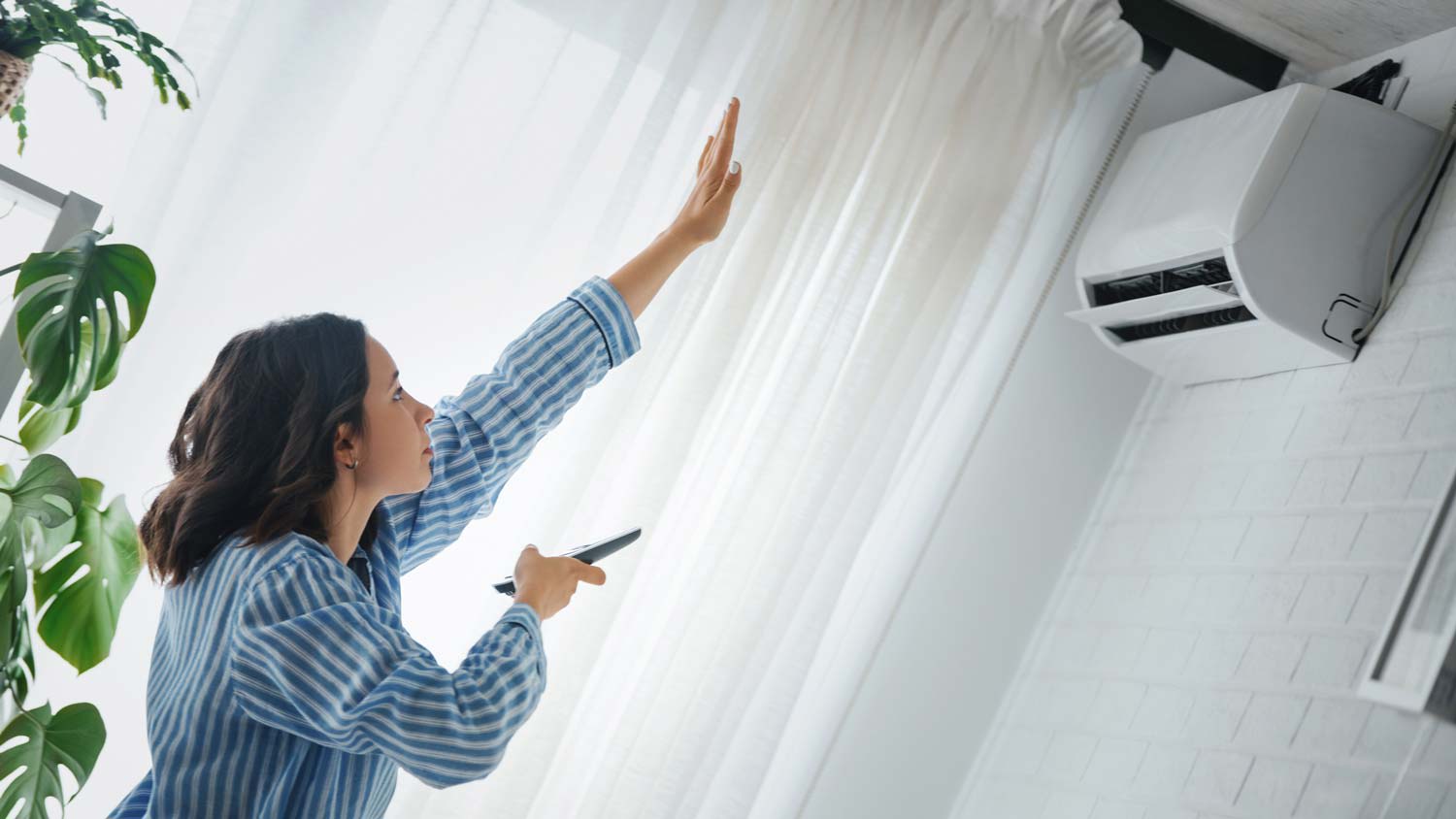 A woman turning on the AC