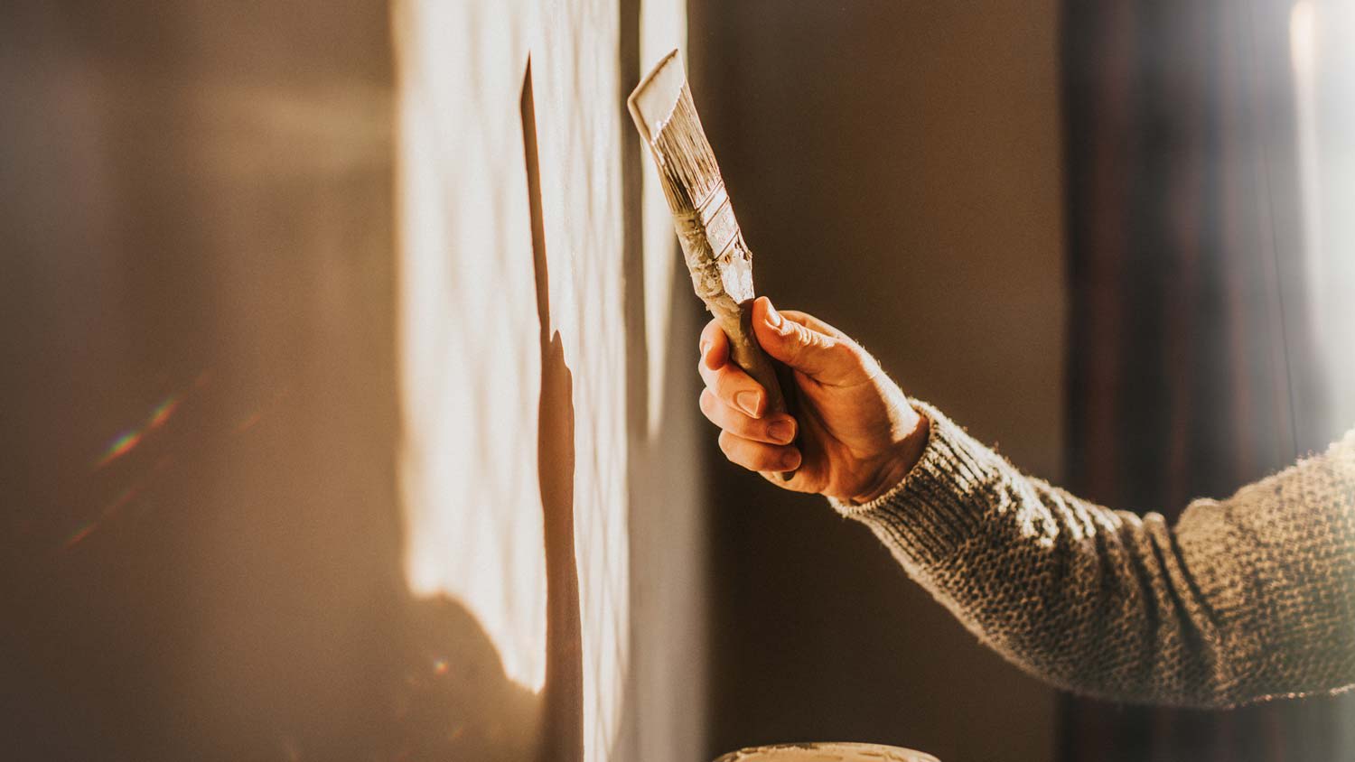 A man painting a wall with a brush