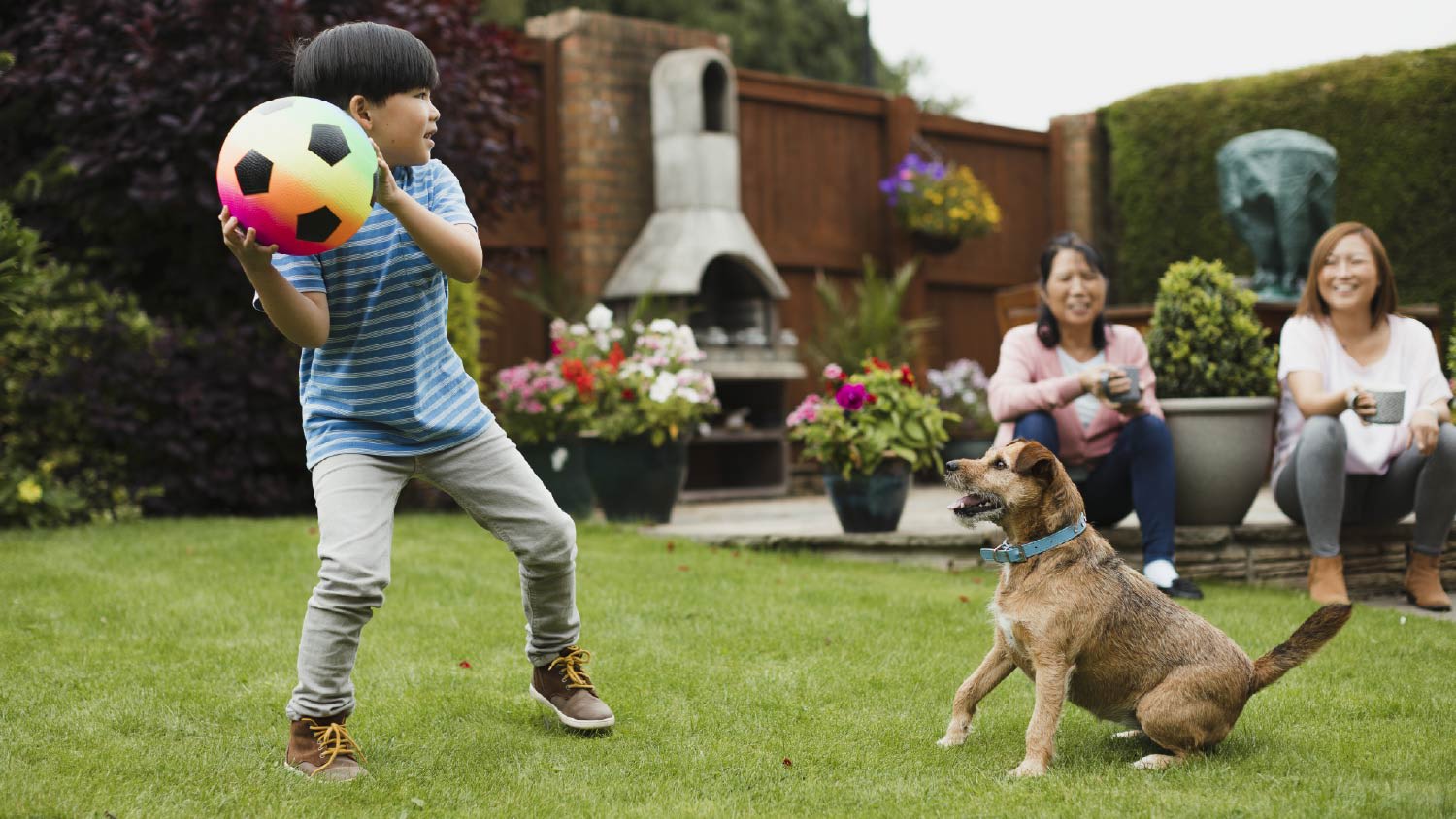Boy playing fetch in the garden