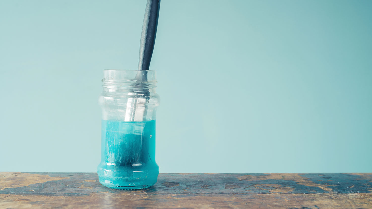 Paintbrush soaking in a jar with paint cleaner
