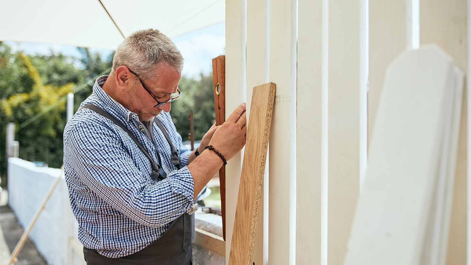 handyman measuring wood plank