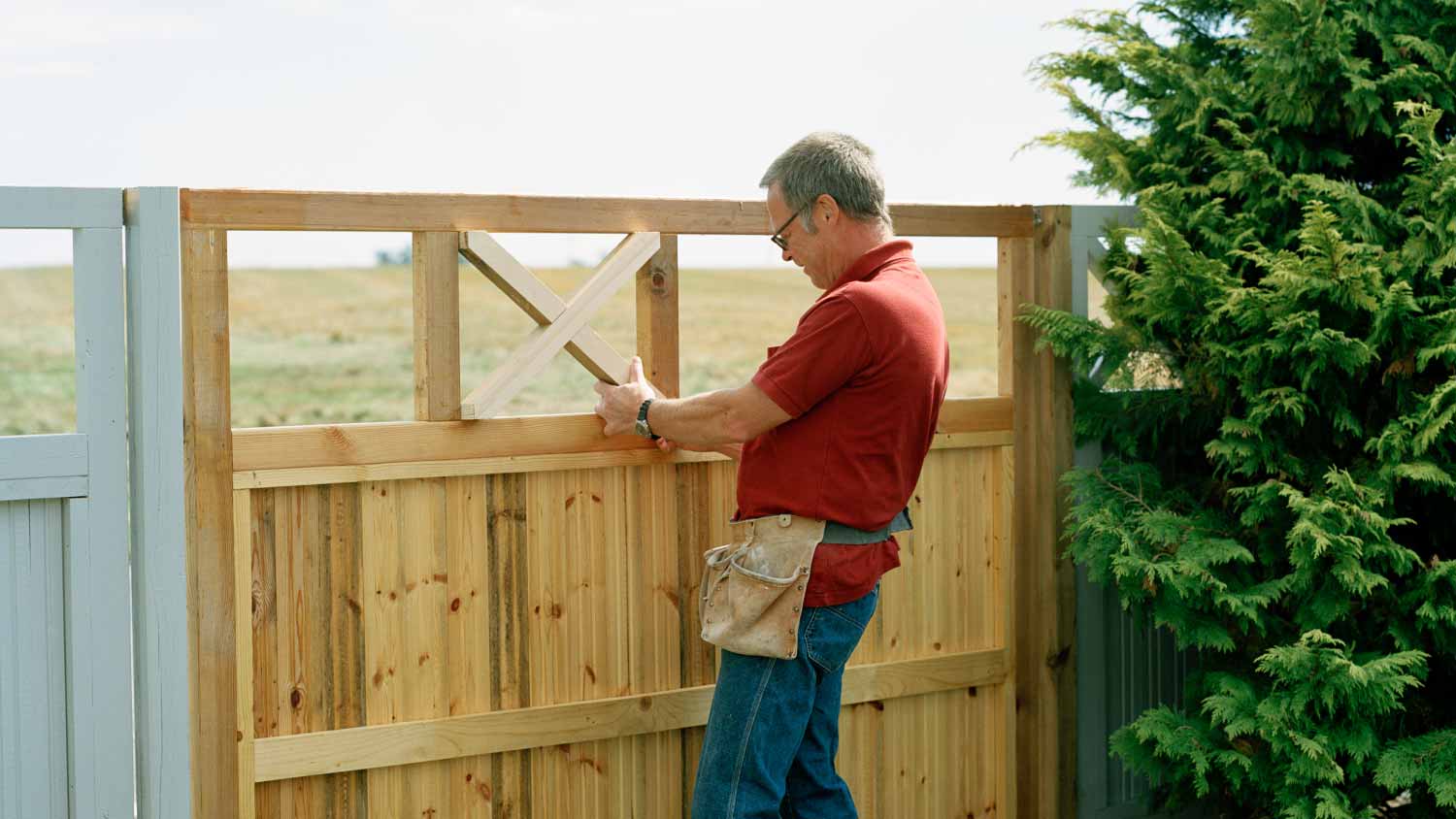 Man building a fence in a garden