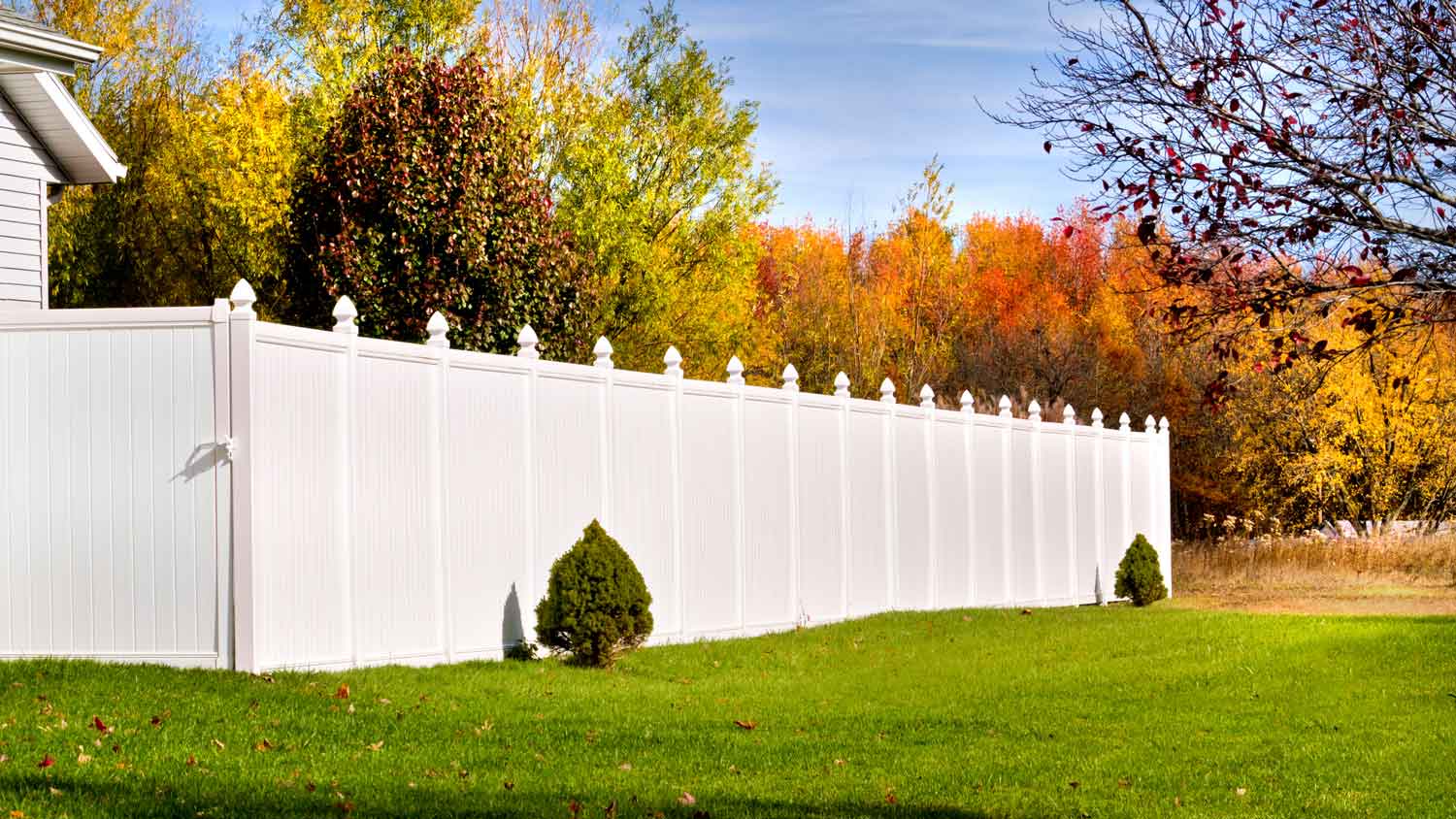 A white vinyl fence on a sunny day