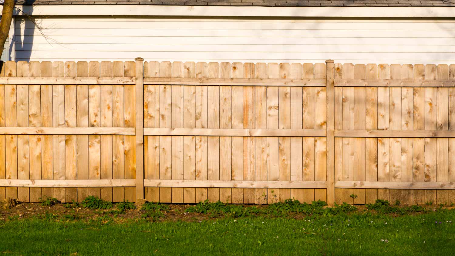 A hard wood fence outside a house