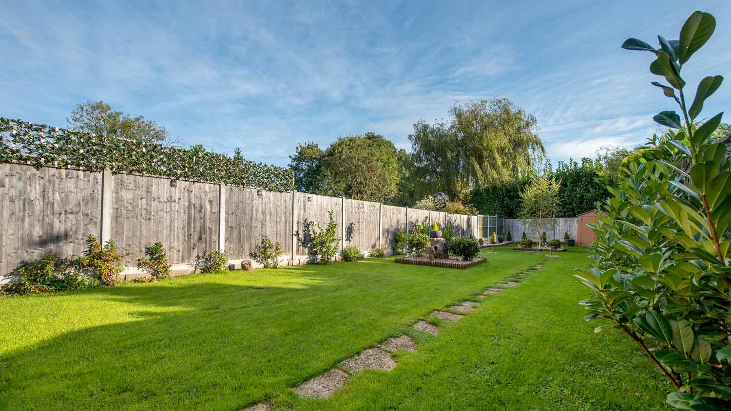 A property’s garden with lawn and timber fencing