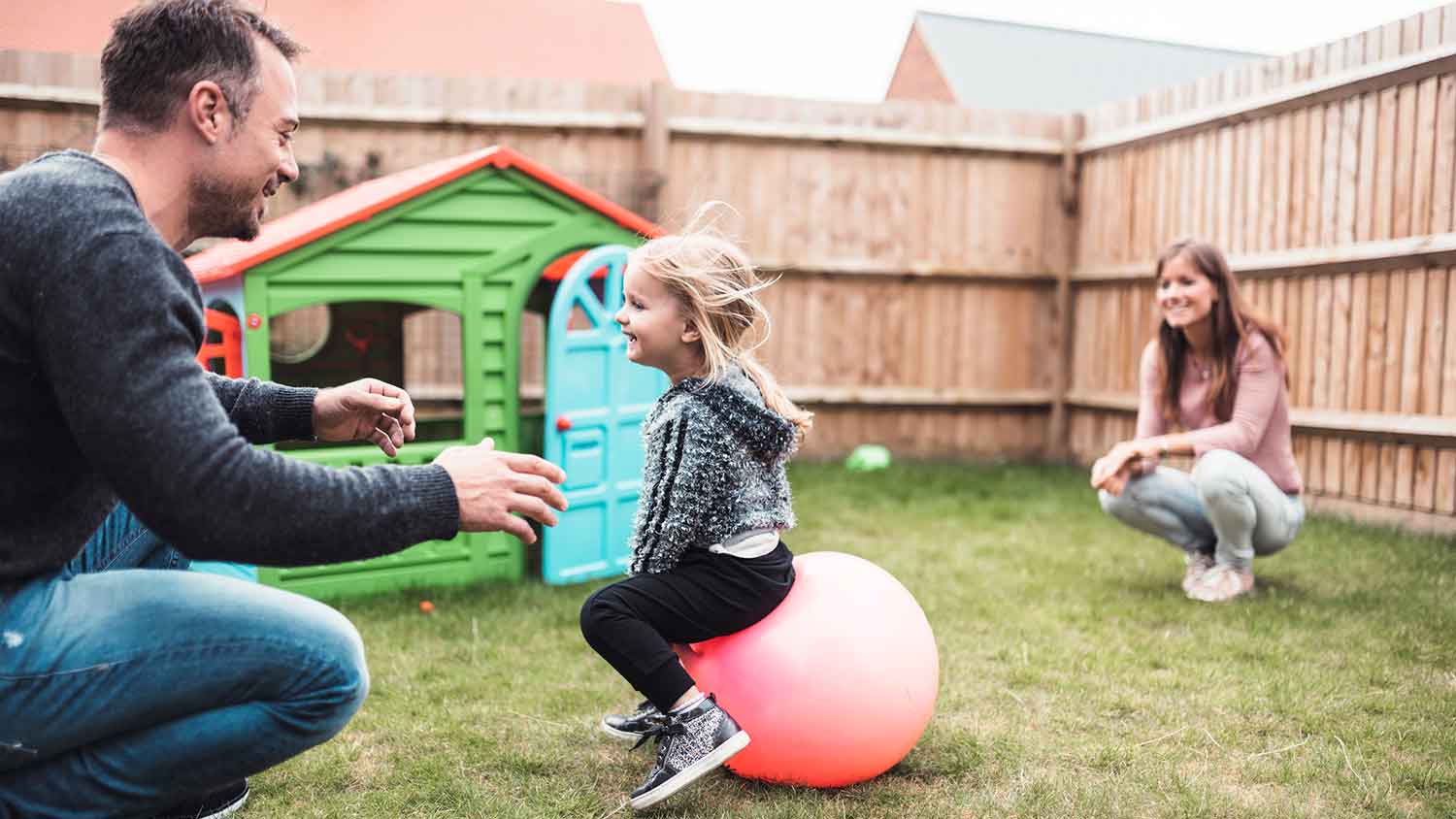 Parents playing with child in the backyard