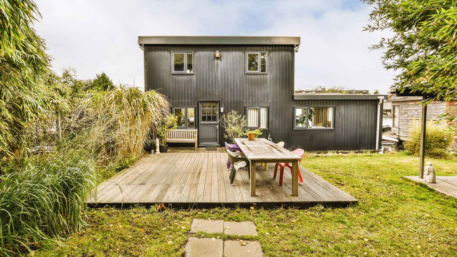 A two story house with a deck in the backyard