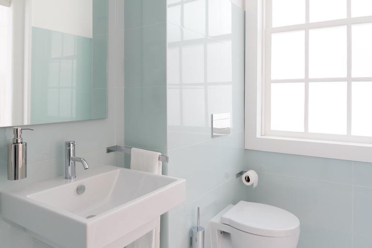 a white and mint green bathroom with modern fixtures