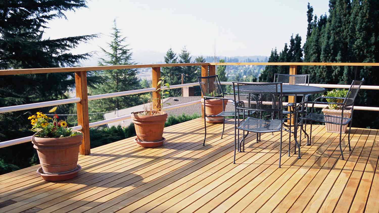 A wooden deck with metal furniture