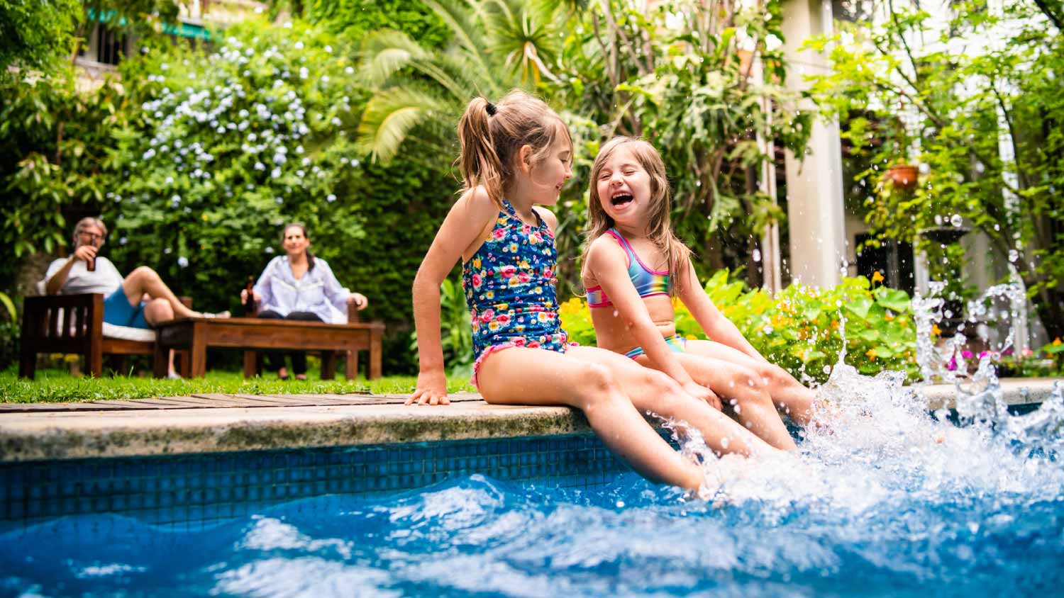 Two little girls sitting at poolside