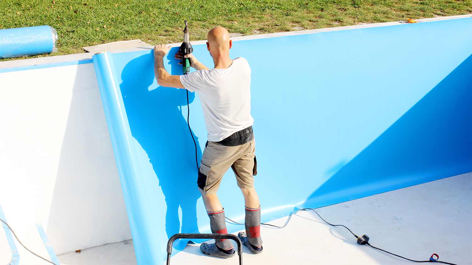 worker installs plastic pool liner
