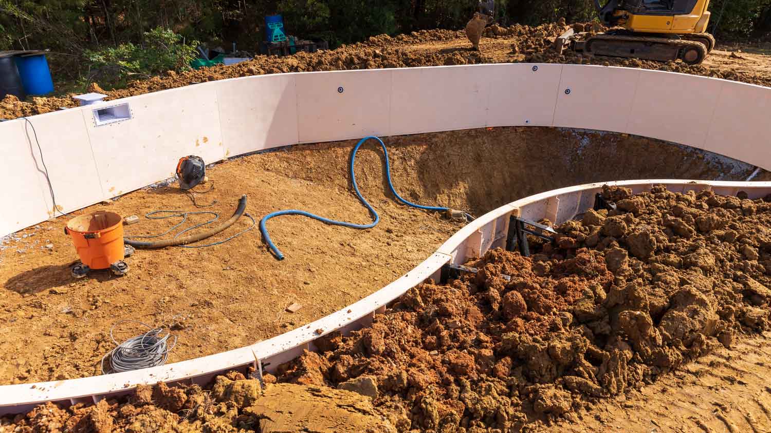 A swimming pool installed in excavated area in house yard