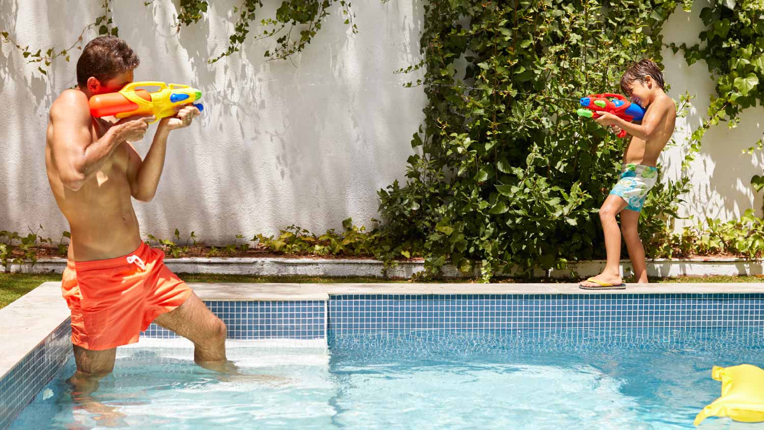Father and son playing at the swimming pool