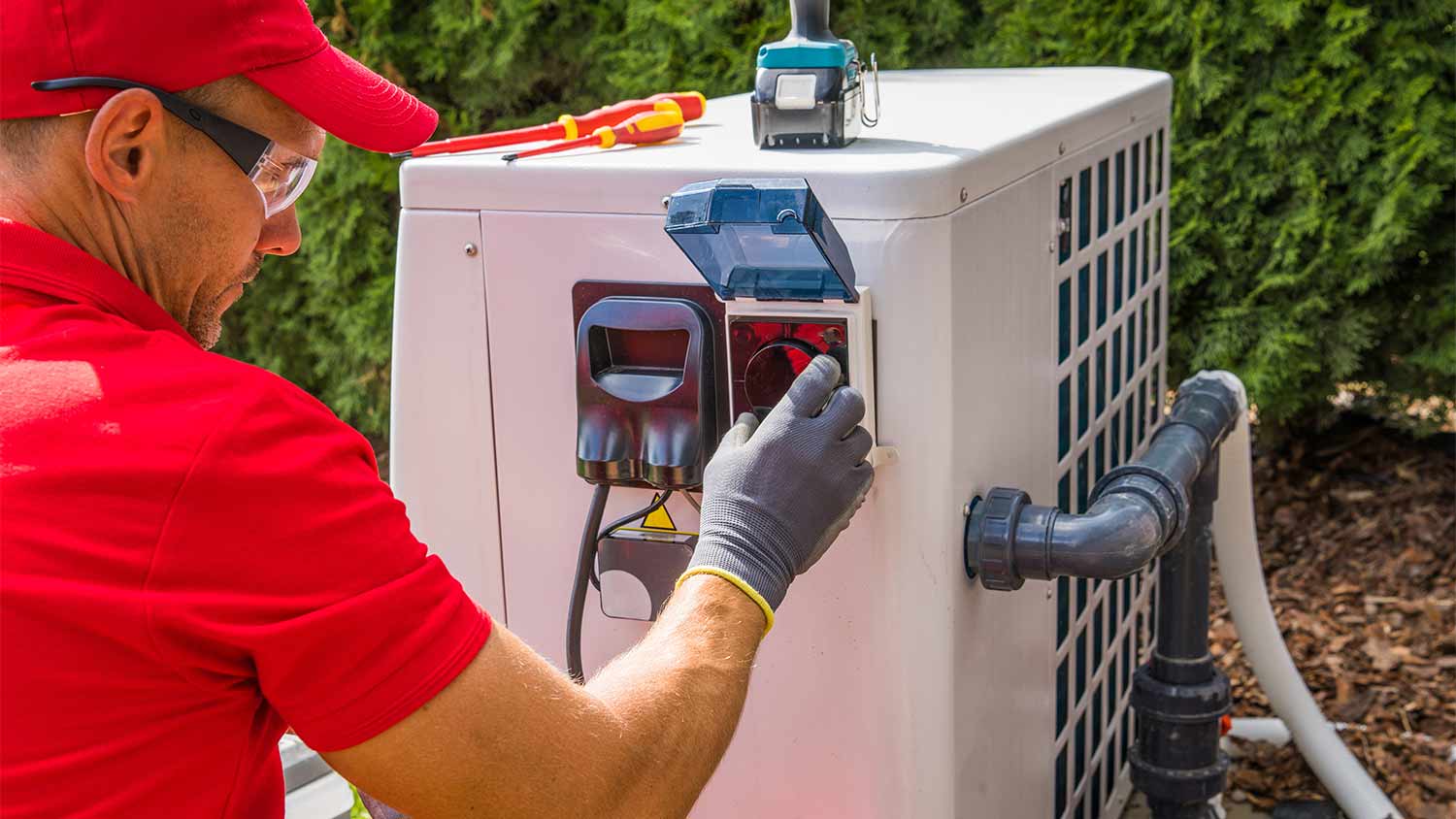 man installing heat pump for pool