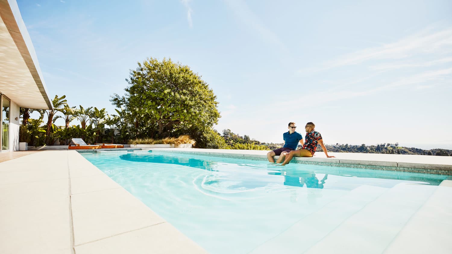 A couple discussing while sitting at the edge of their pool