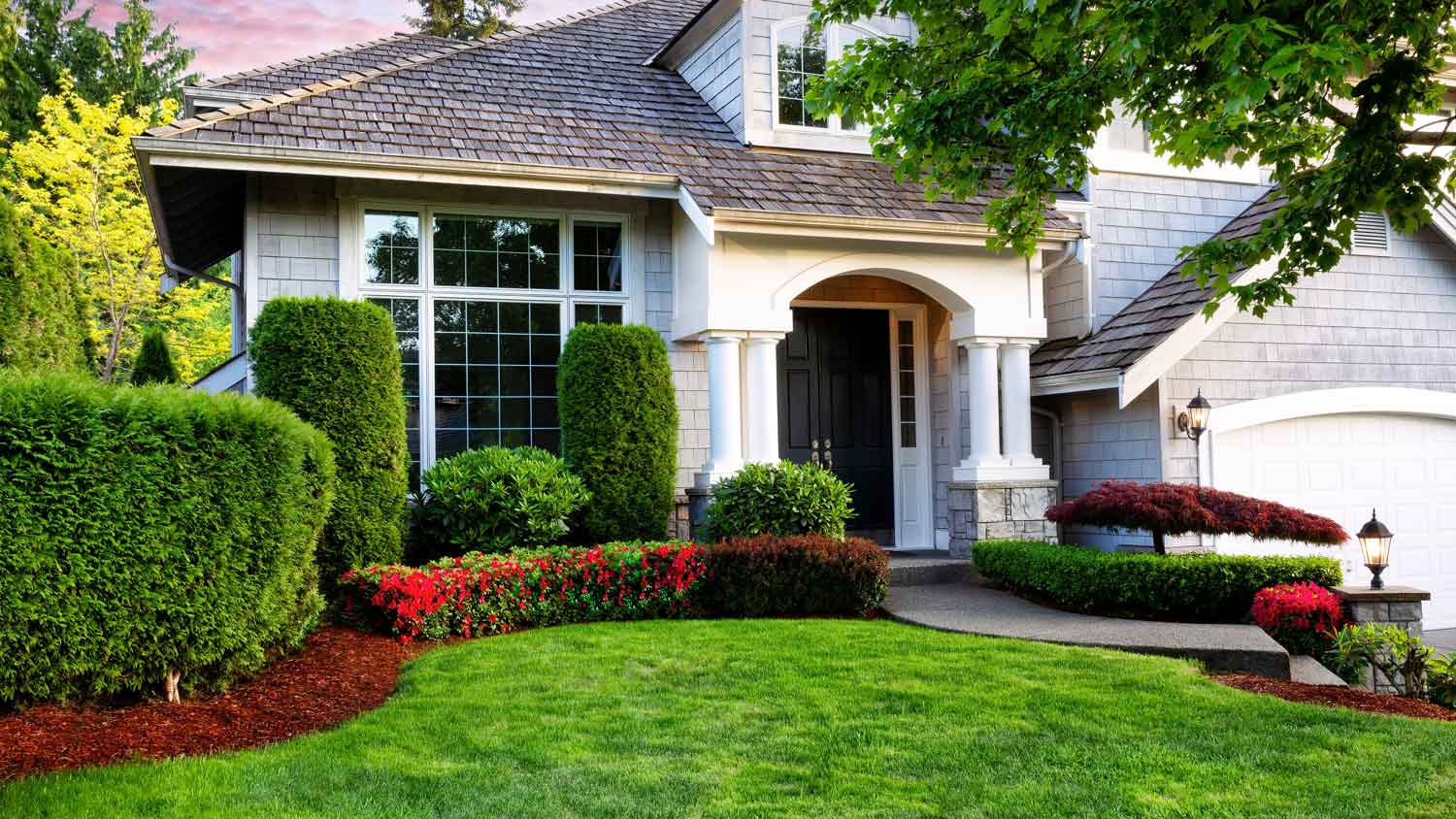 A house with a beautiful garden filled with shrubs and bushes