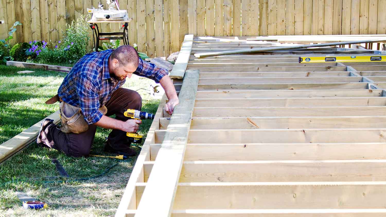 Carpenter using drill to build a patio deck