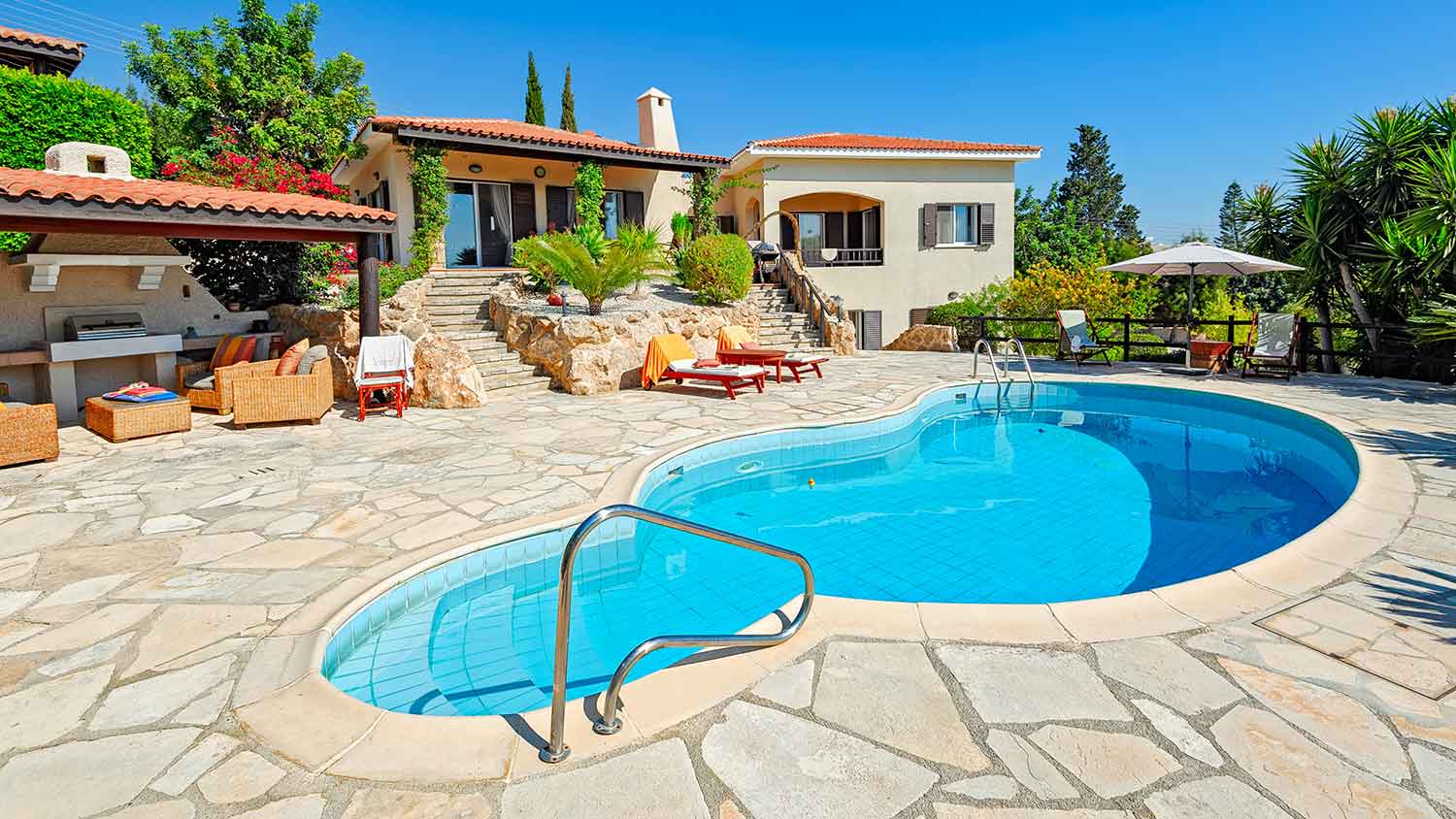 Large patio area with swimming pool and lounge chairs