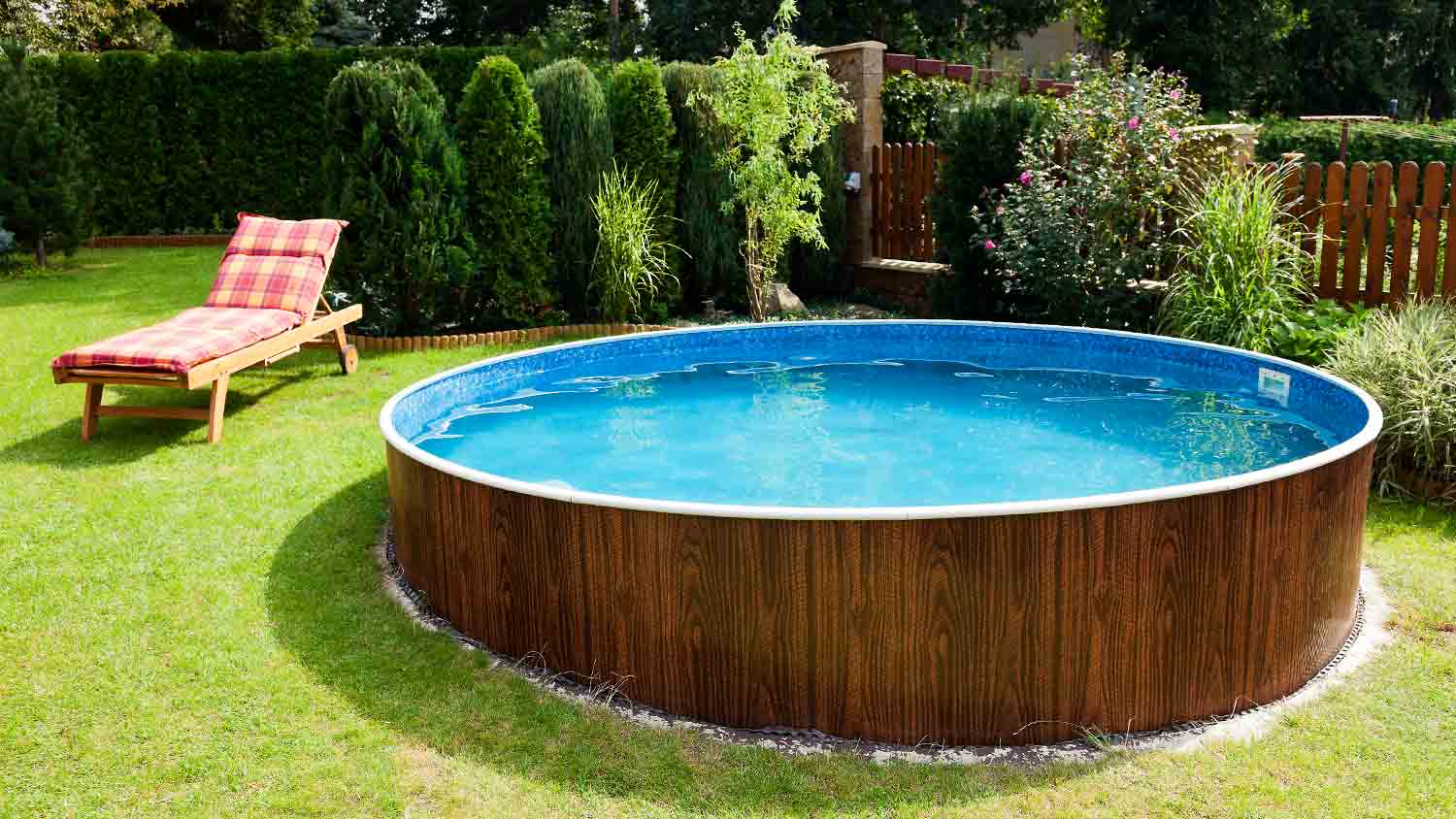 round above ground pool with deck chair in yard