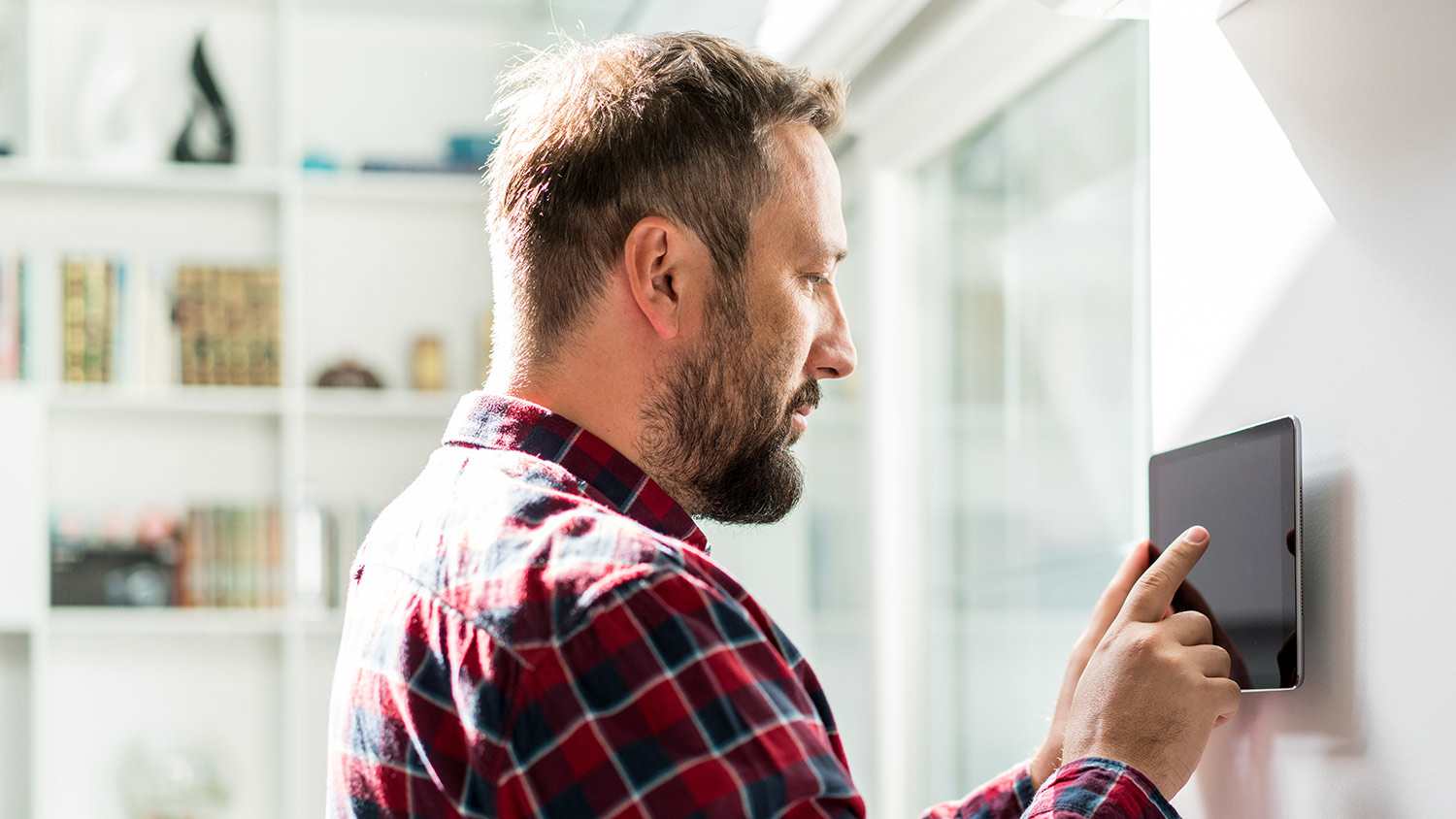 Man using smart home thermostat device
