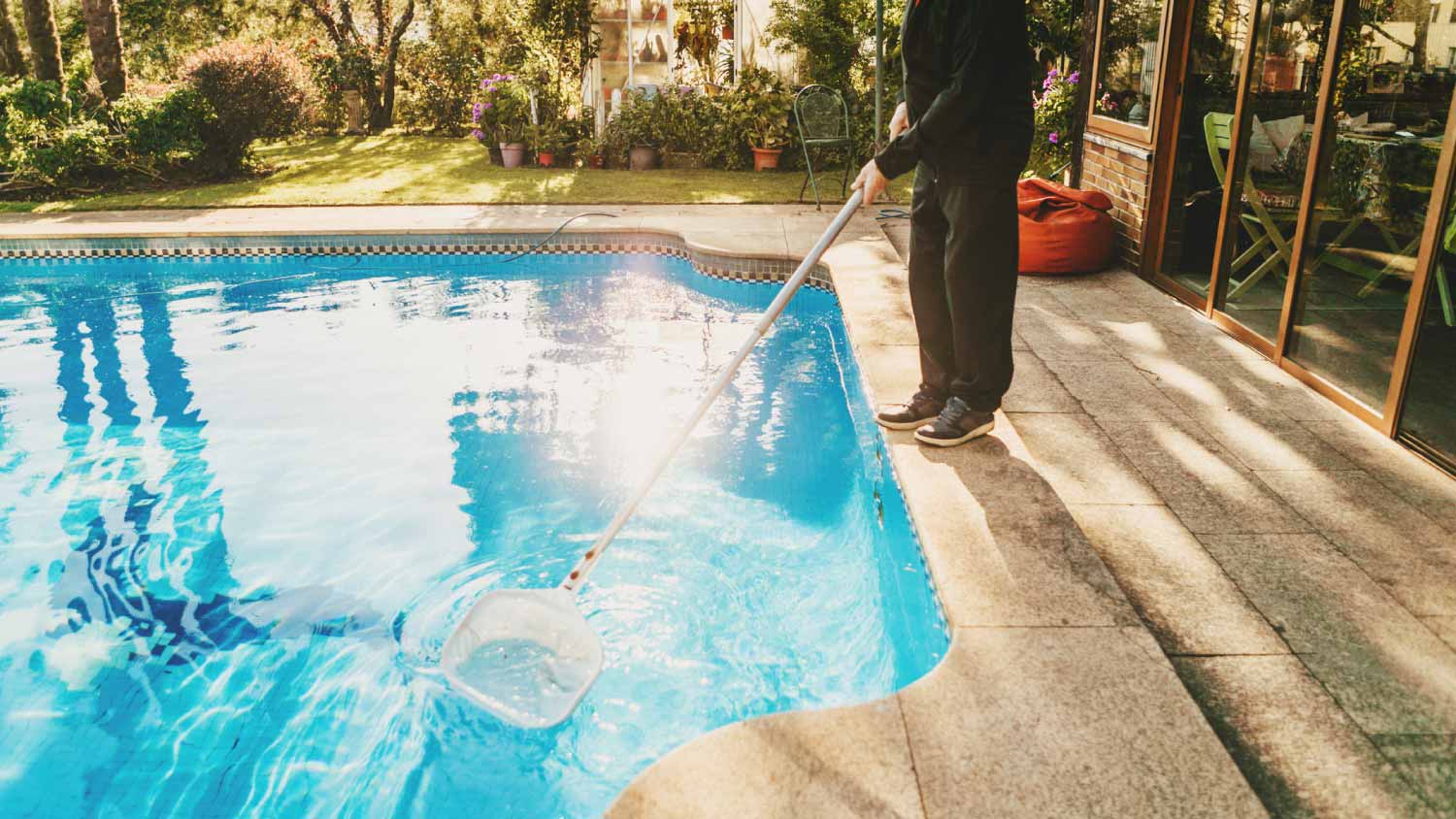 A man cleaning the pool