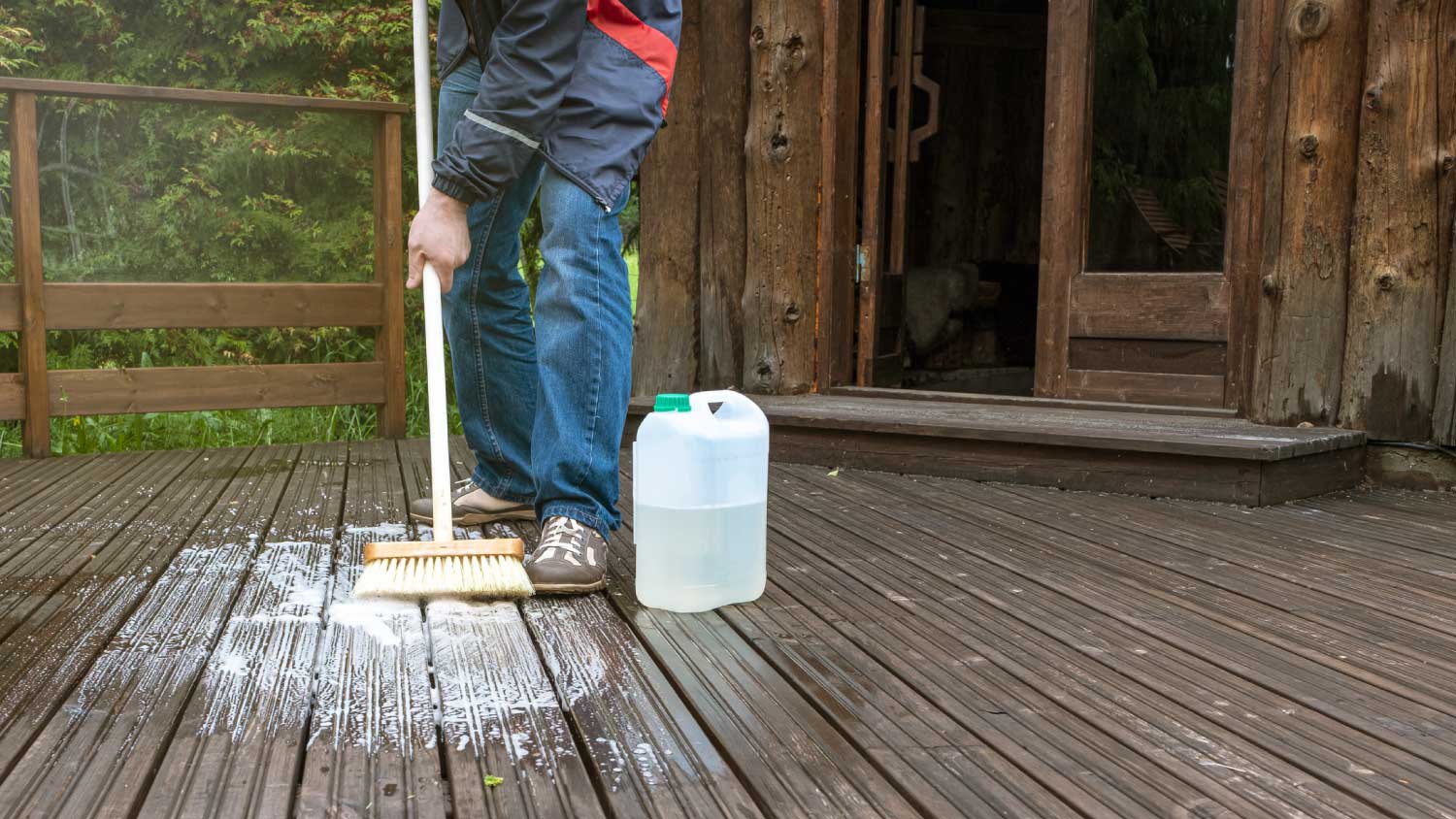 Man cleaning wooden terrace