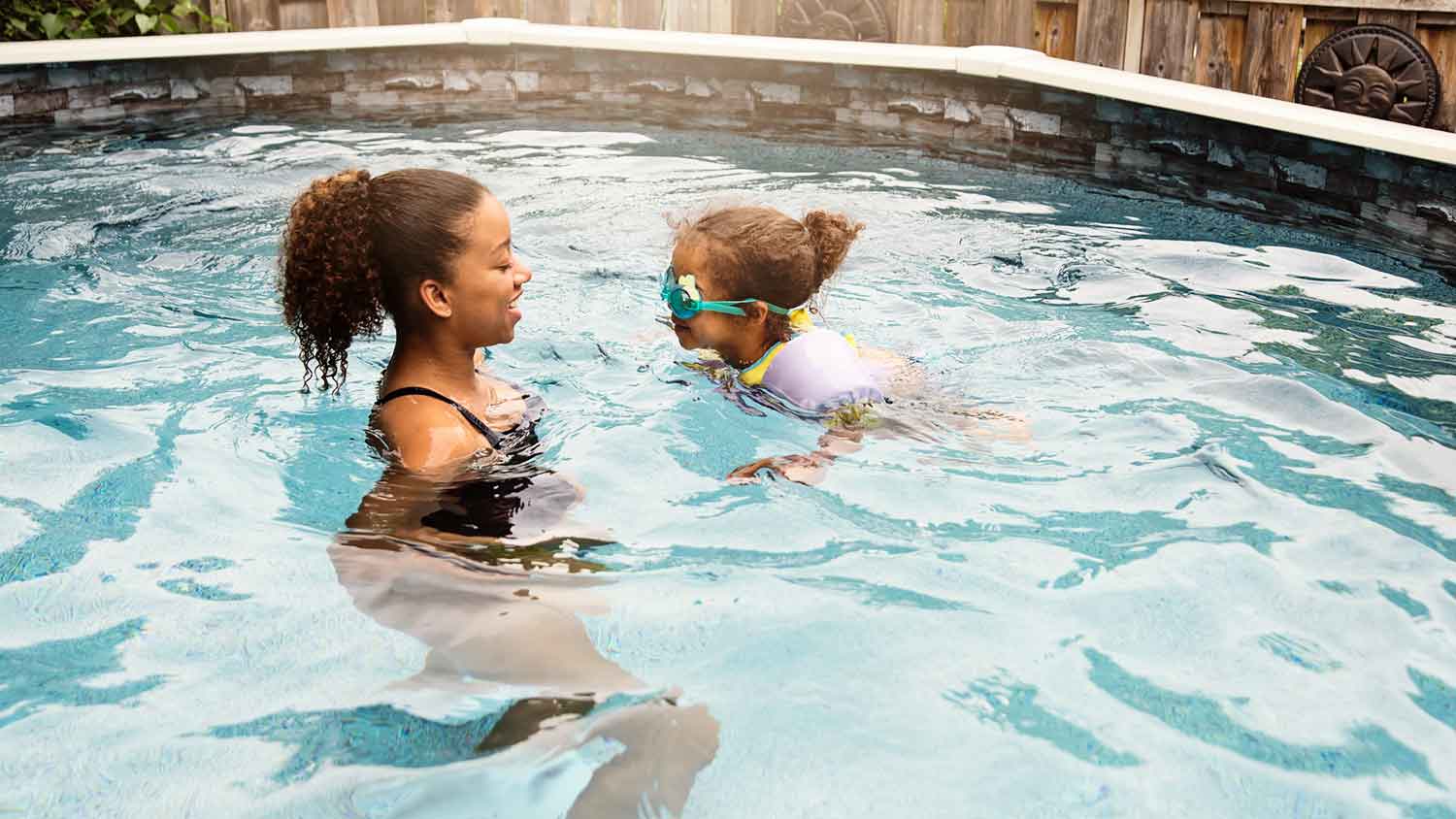 Older sister teaching her little sister how to swim