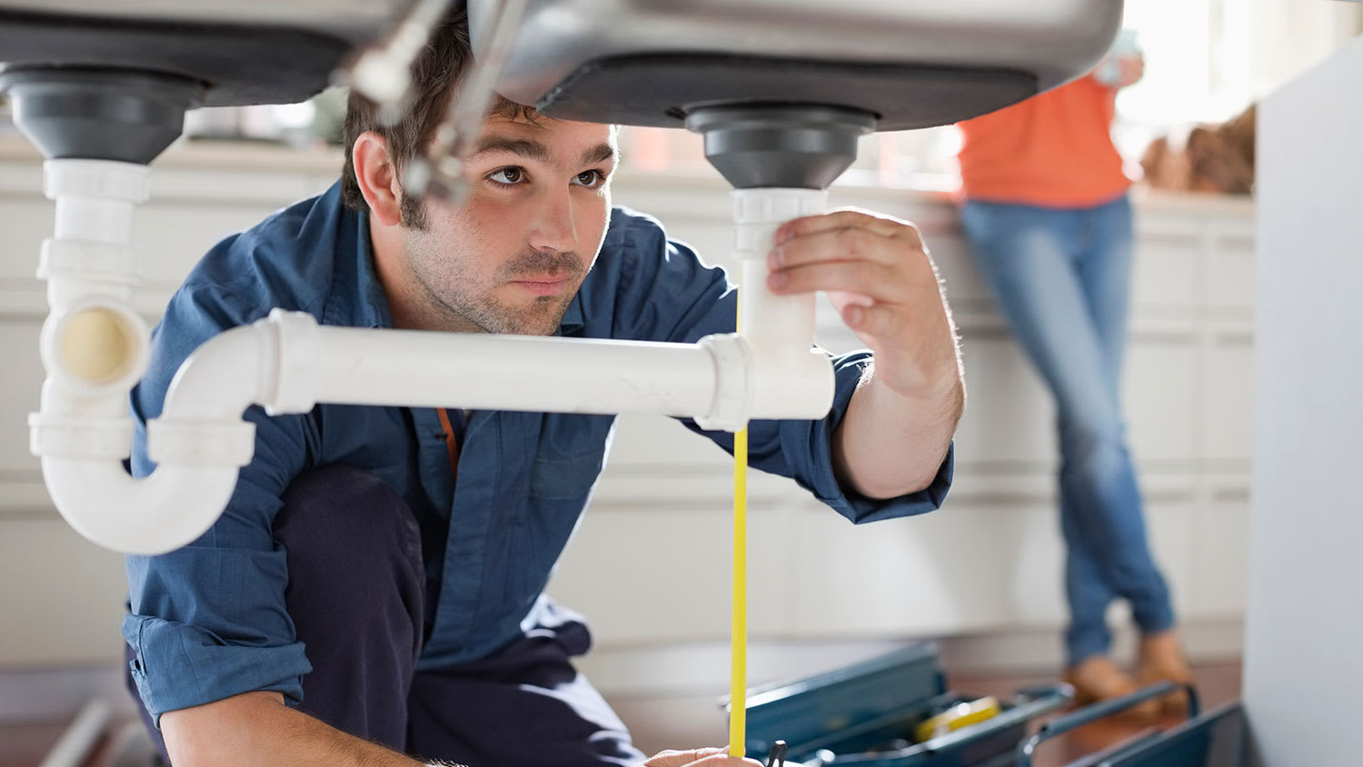 Plumber measuring drain pipe