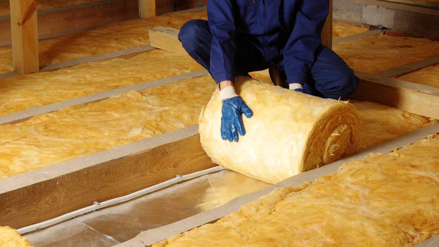 Worker insulating house attic