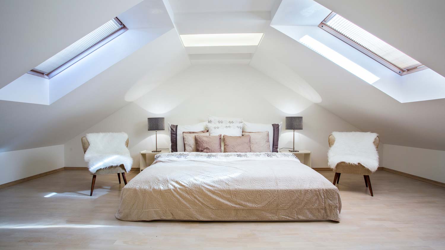 A minimal bedroom located in the attic of a house