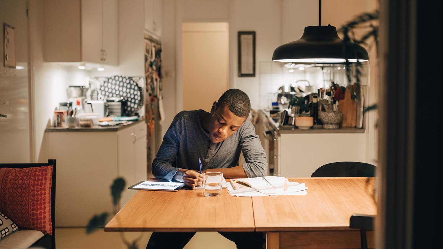 Young man doing his homework in the dining room