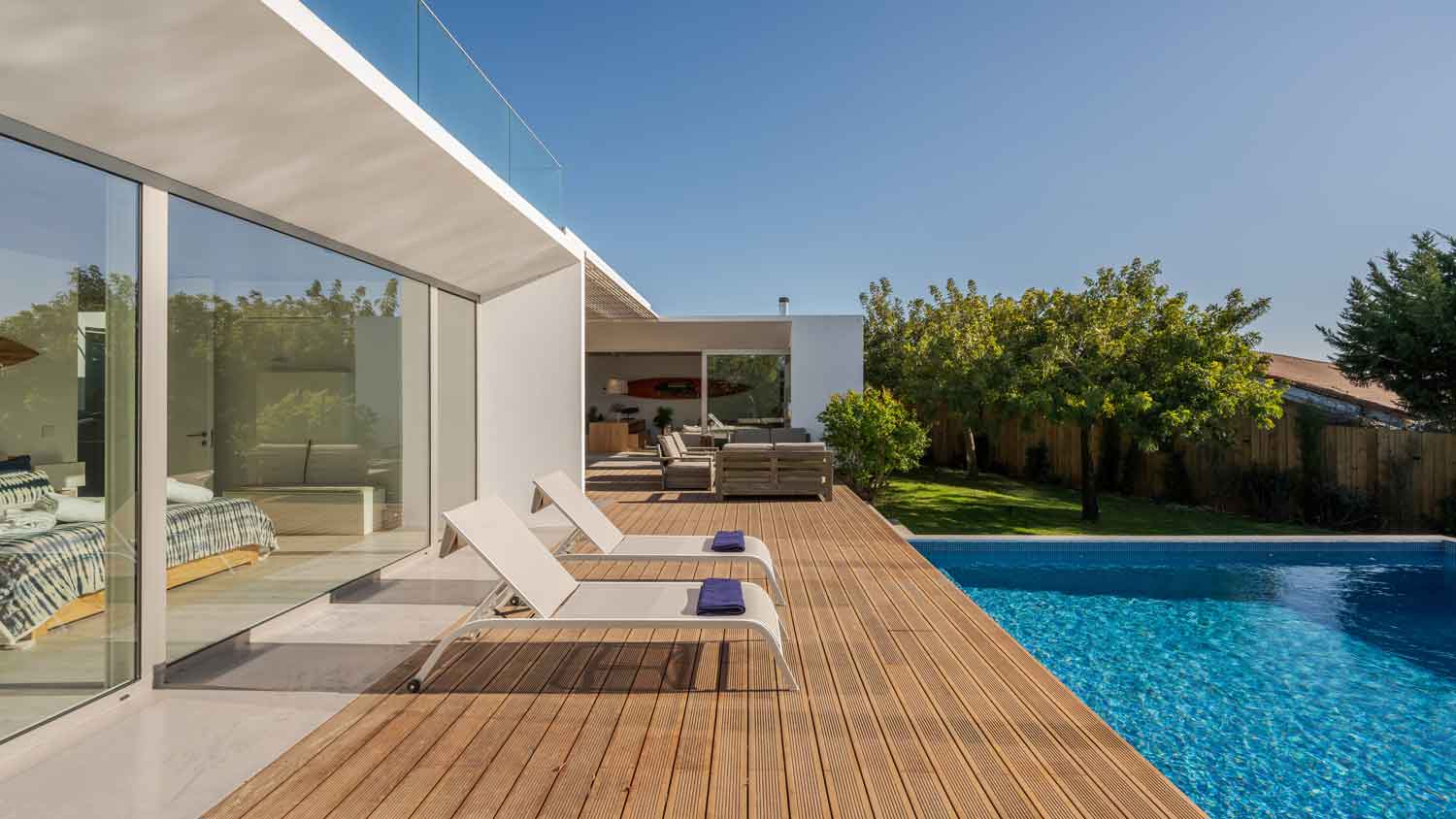 A beatufitul house with a swimming pool and a wooden deck