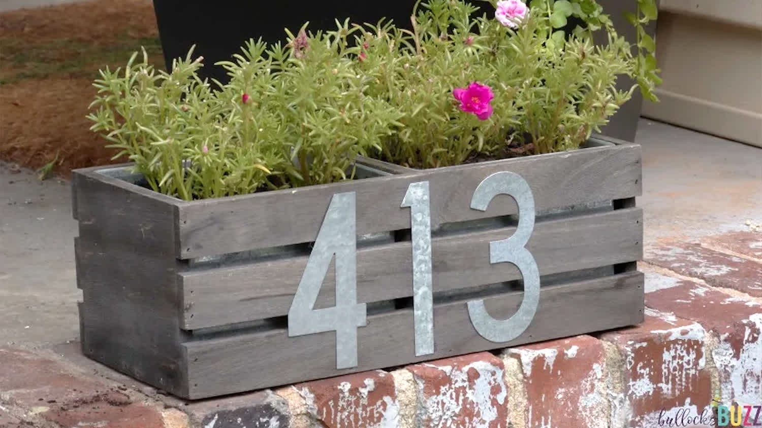 #413 on wood planter with flowers on front porch