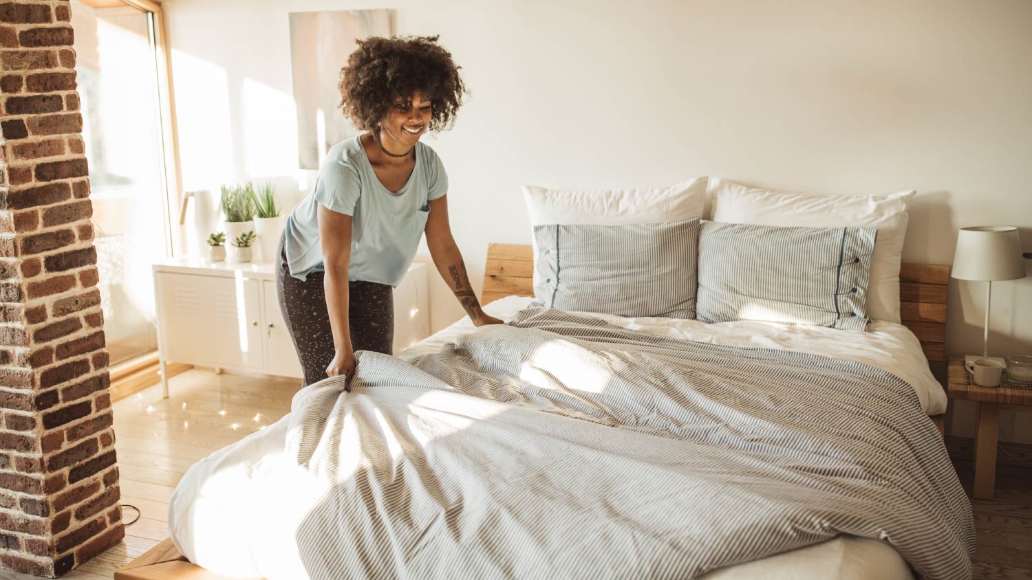 woman making up guest bed
