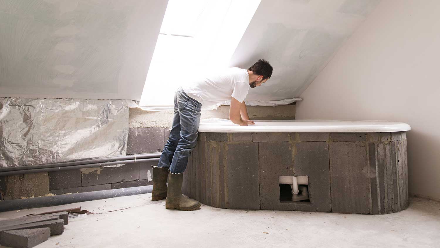 Man installing new bathtub and renovating the bathroom