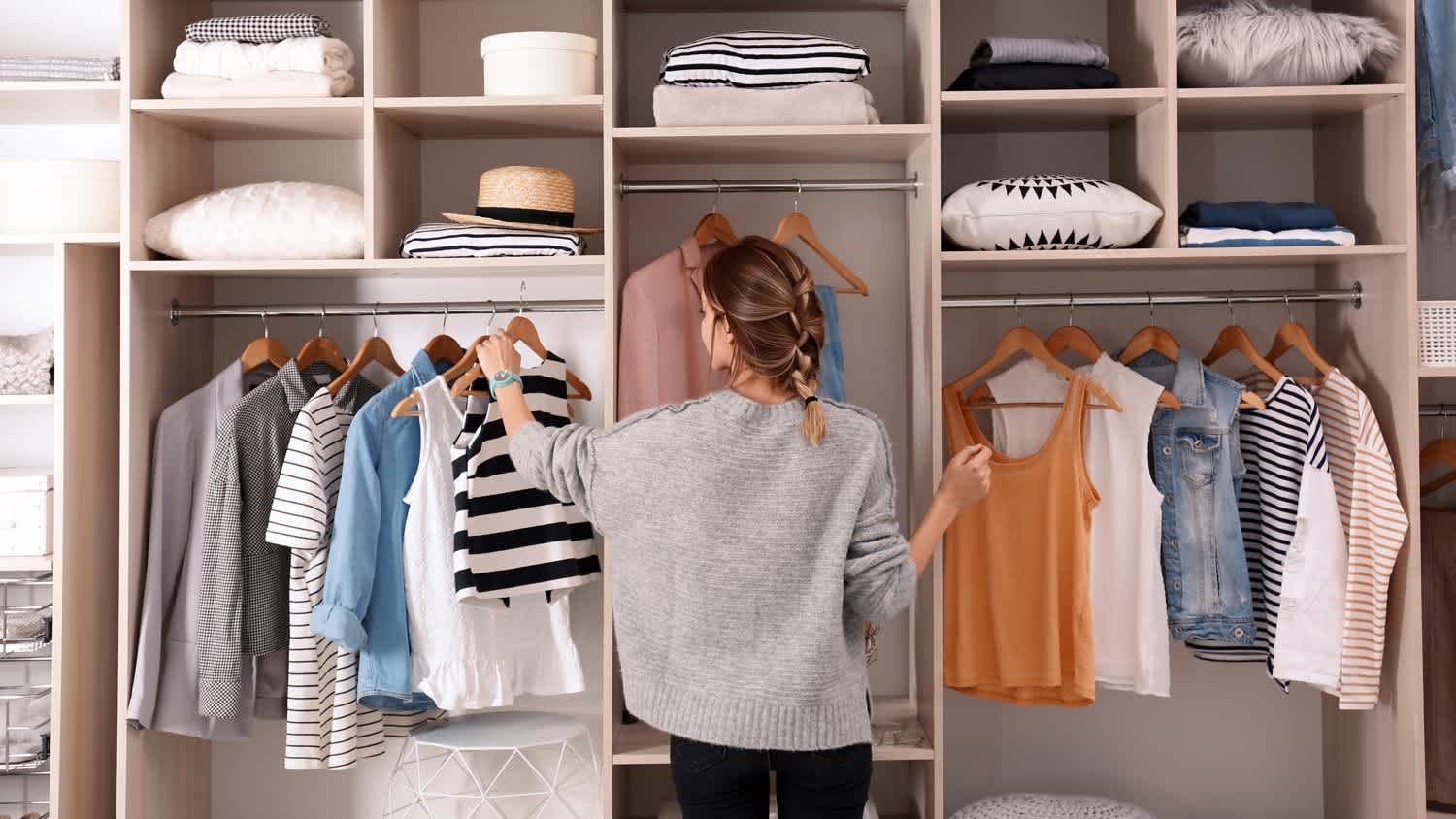 A woman trying clothes in front of her mirror