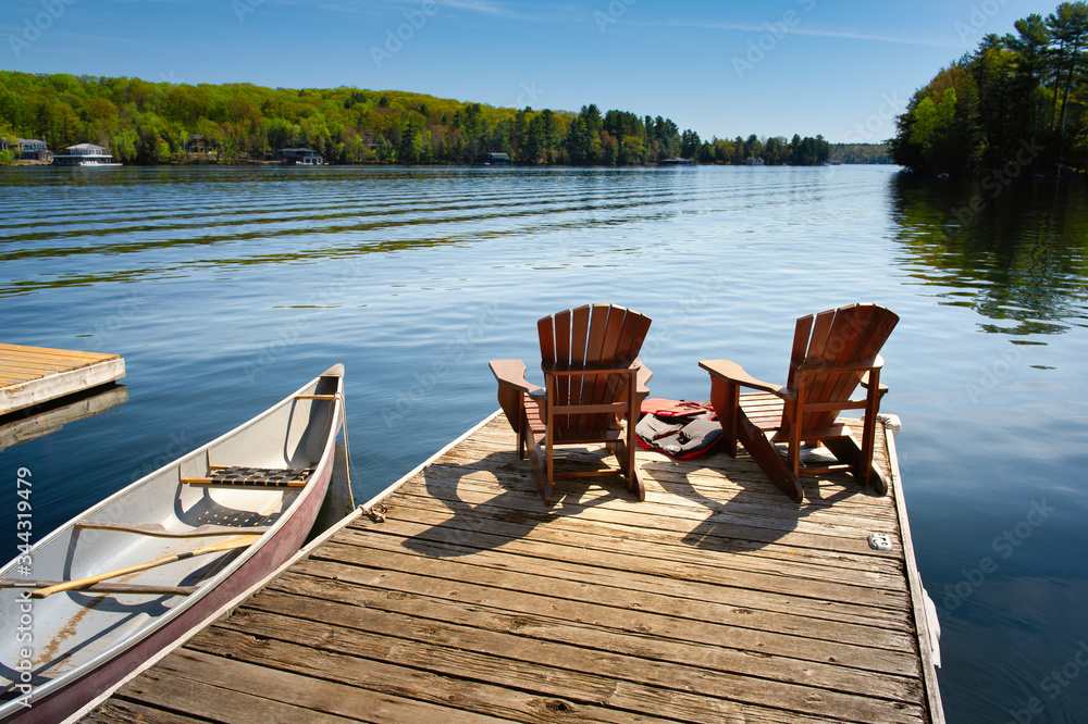 Two adirondack chairs on a wooden dock