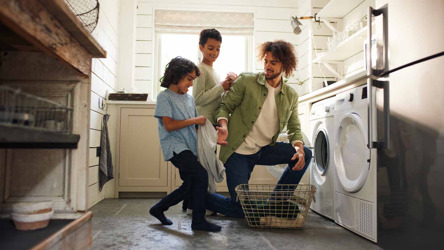 A father with his sons loading the washing machine
