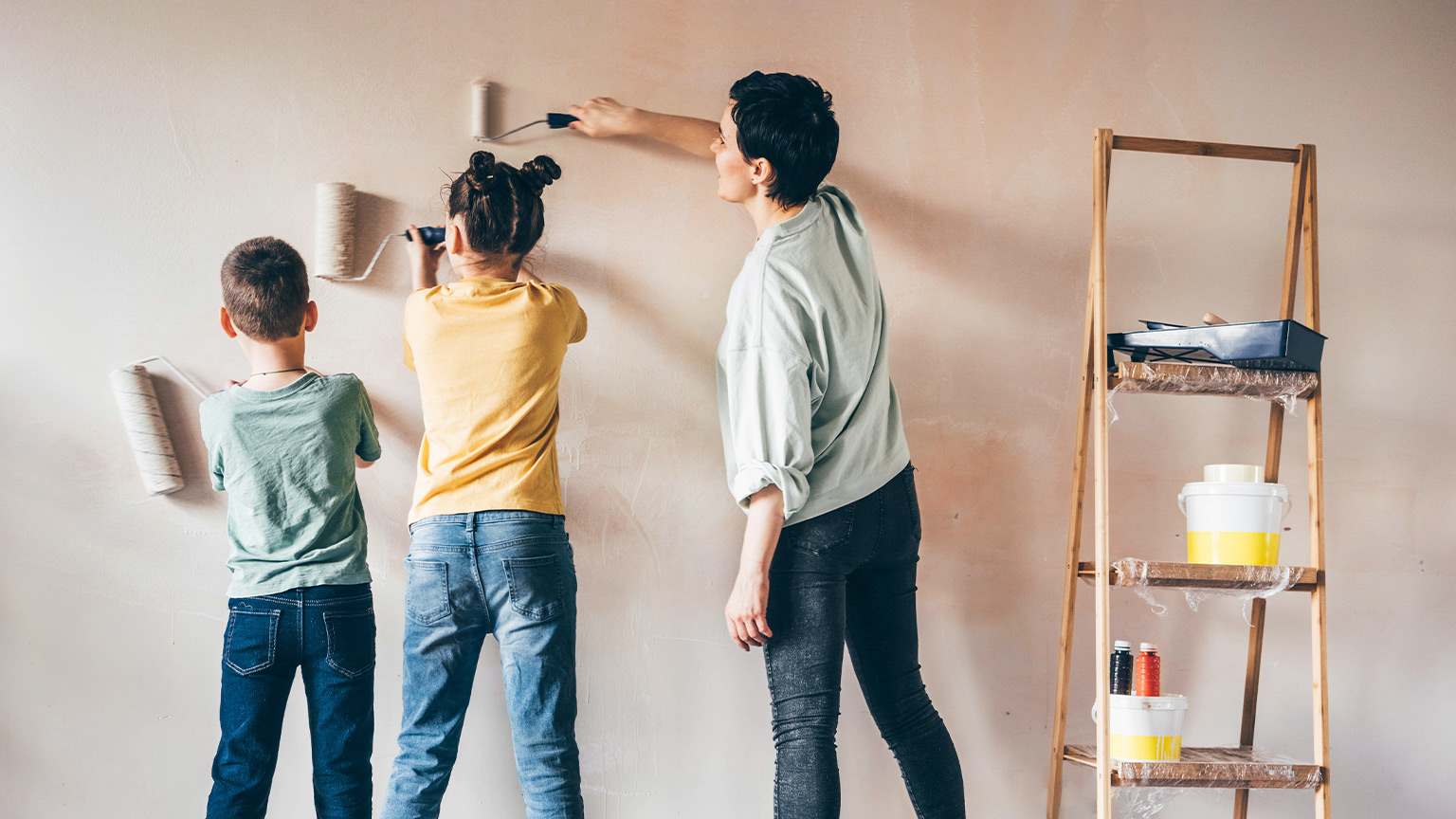 mom and two kids painting wall