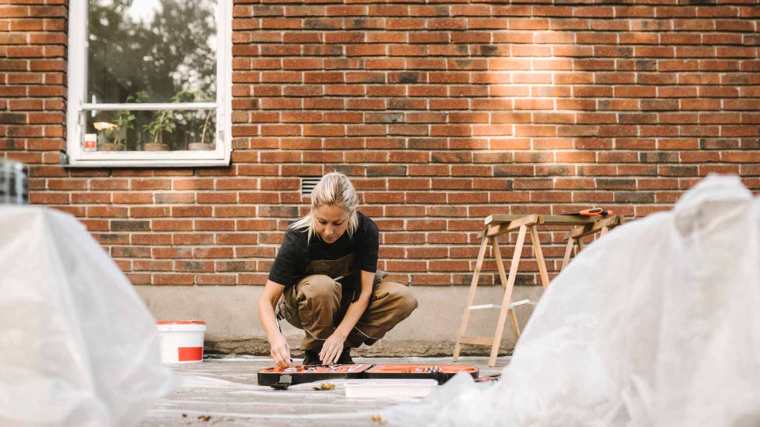 Woman crouching while renovating house