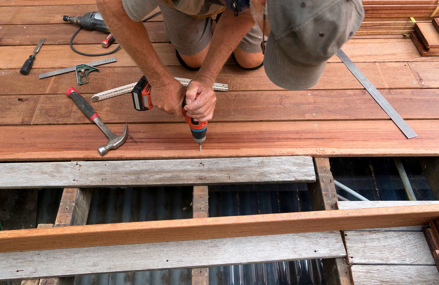 man fixing deck with drill