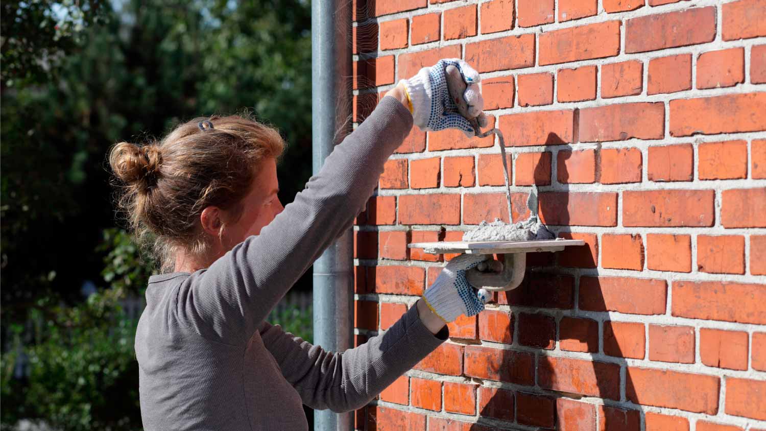 A woman working on the brick wall
