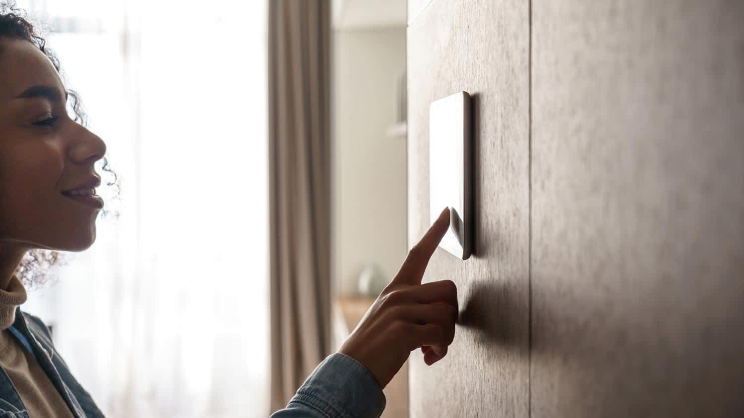 A young woman operating a smart home screen