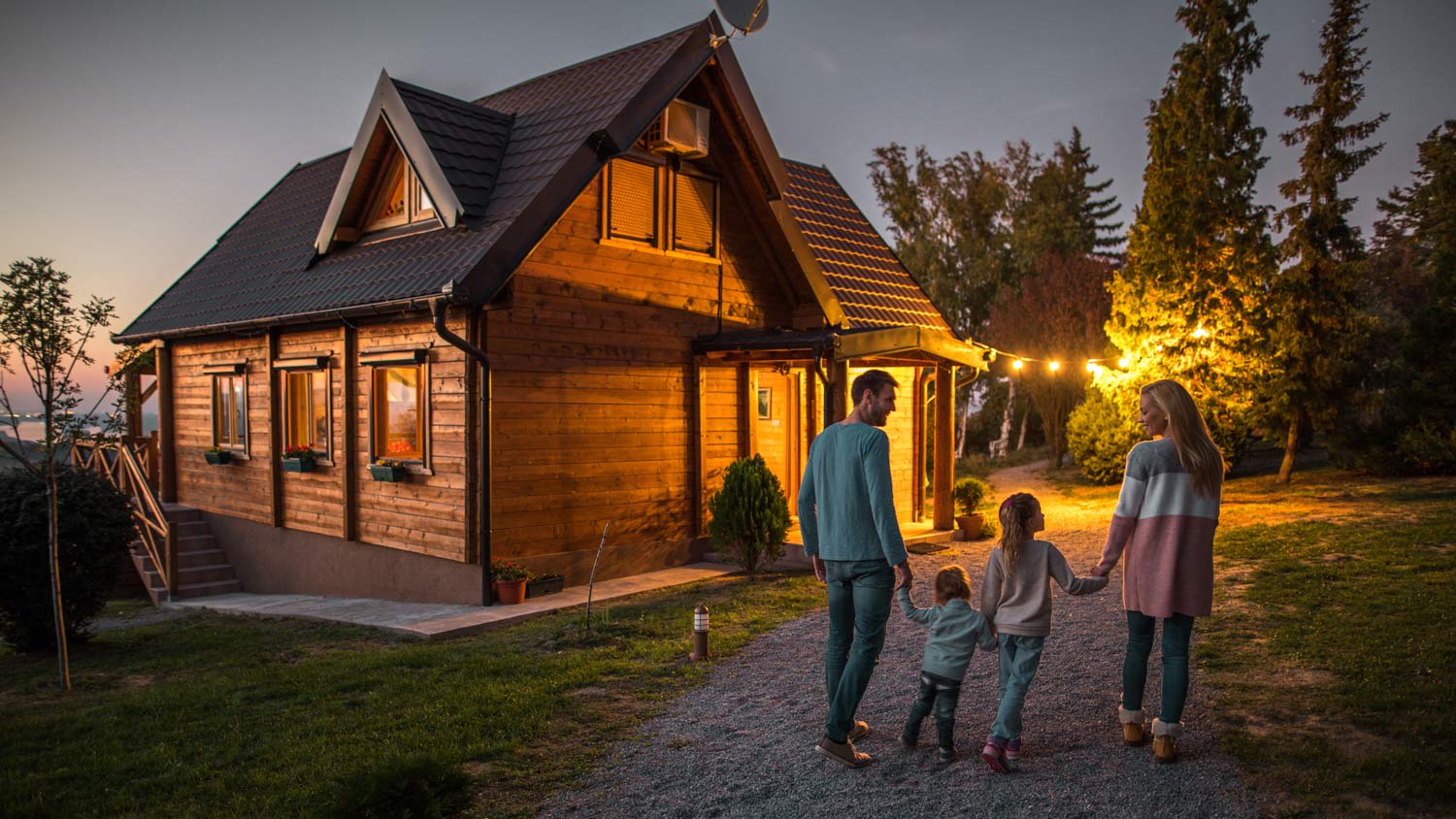 A happy family walking by their chalet in the evening